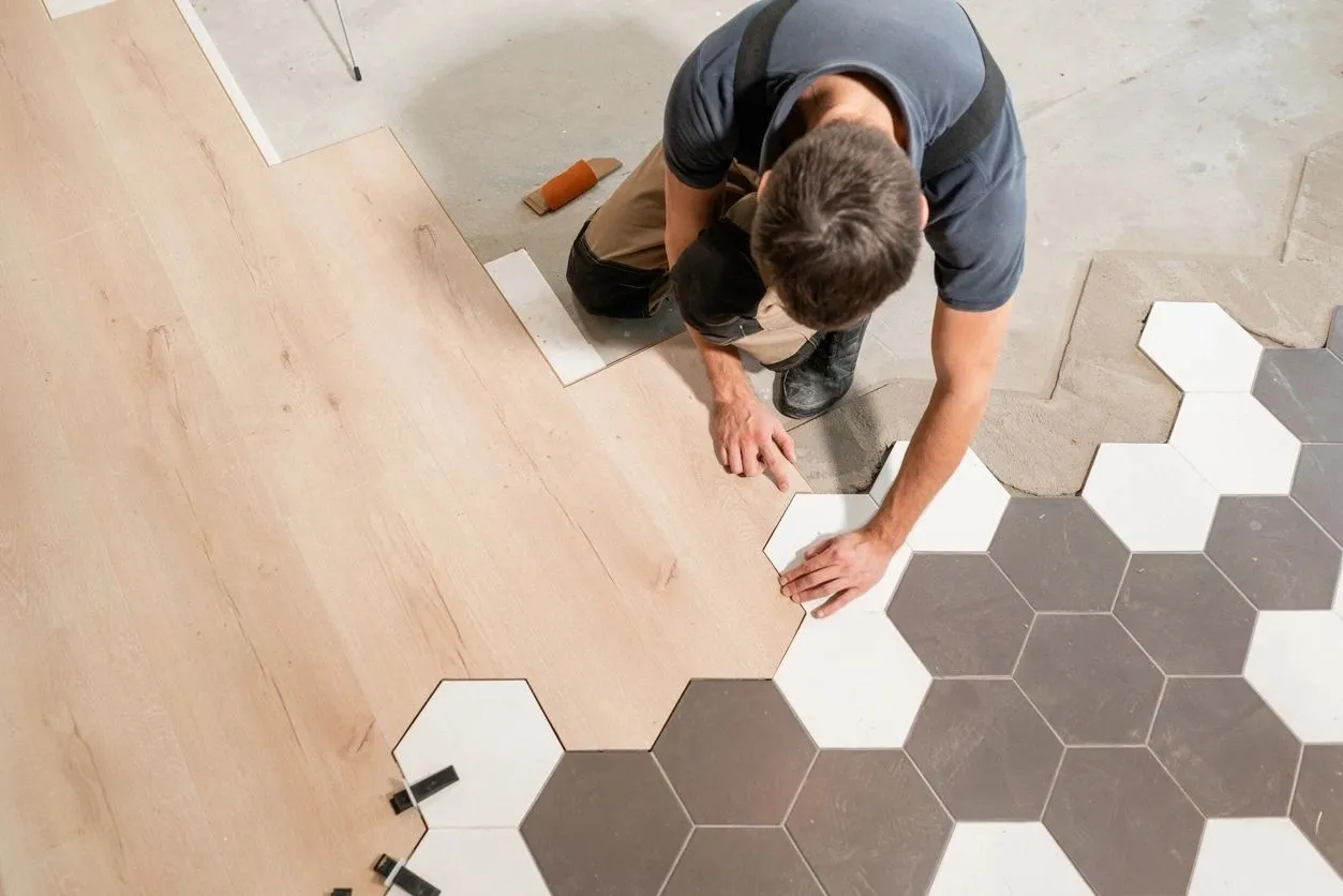 A man is working on the floor of his home.